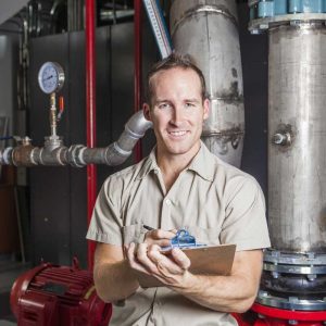 technician standing in front of a boiler